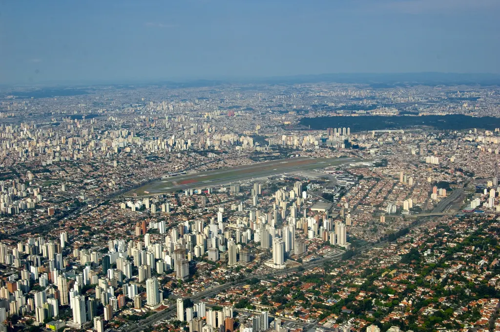 Vista aérea de São Paulo com a pista do Aeroporto de Congonhas cercada por bairros densos